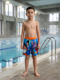 Short de bain Dragon Ball Super bleu à ceinture orange porté par un garçon au bord d’une piscine