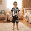 Ensemble garçon University 68 noir et blanc porté, t-shirt à éclaboussures et short noir avec quatre étoiles