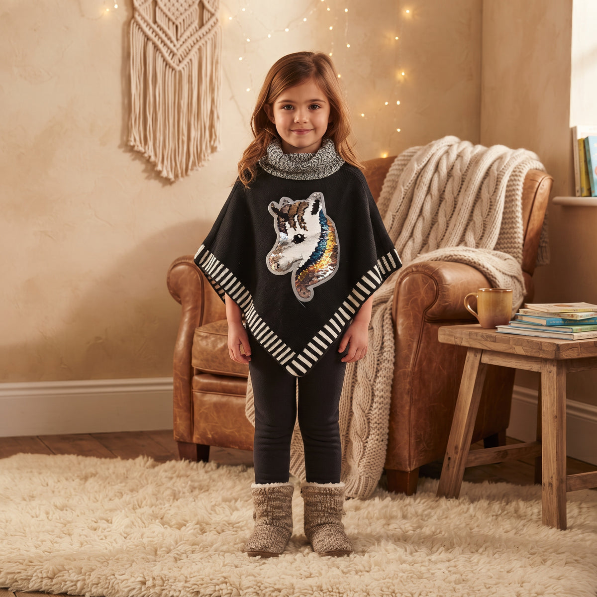 Poncho fille noir porté, licorne à sequins réversibles, col roulé chiné et bordures rayées noires et blanches