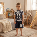 Ensemble garçon University 68 porté, t-shirt blanc et bleu marine à éclaboussures et short marine assorti